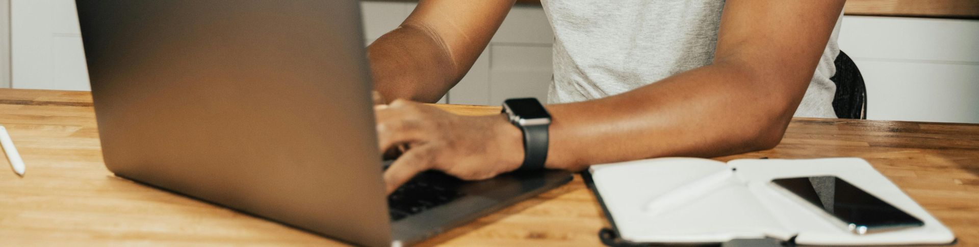 African American man smiling while working remotely on laptop from home office